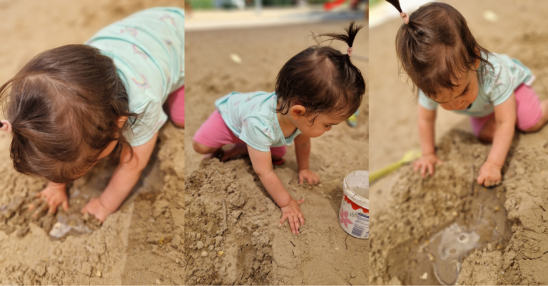 A toddler playing in a sandpit, pressing both hands into the sand and exploring the texture — one of the simplest and most absorbing toddler learning activities for children under 2.