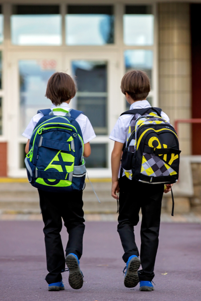 Two boys walking to school wearing kids backpacks for school