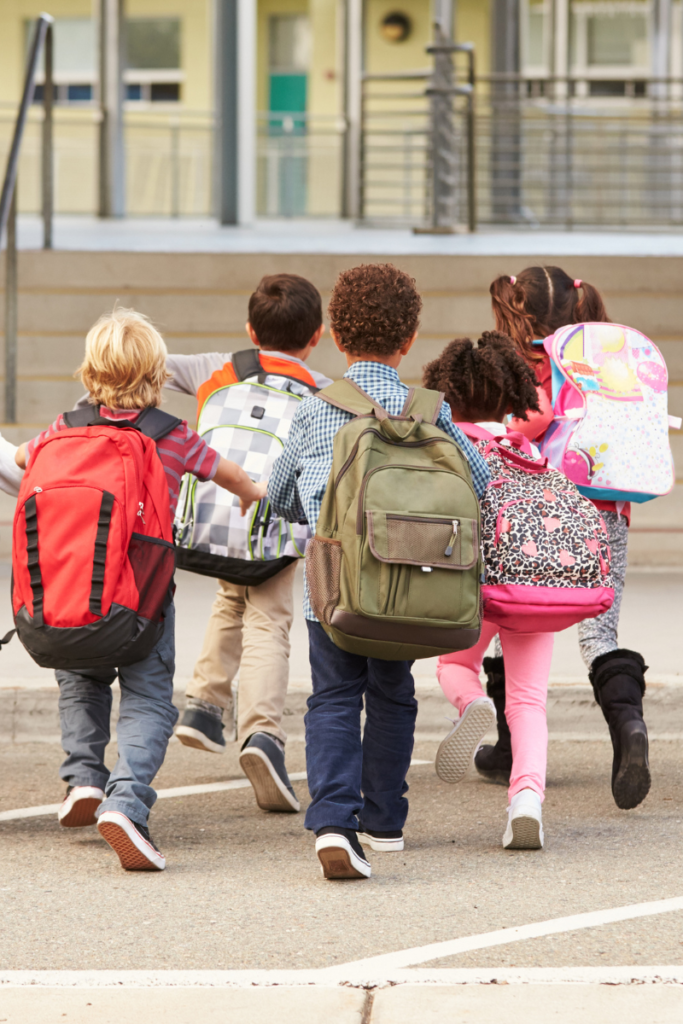 Group of kids running to school wearing different school supplies backpacks